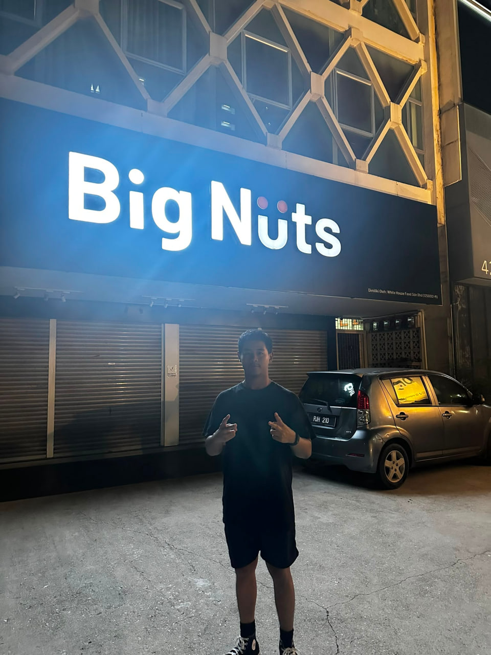 Derek in front of a Big Nuts sign